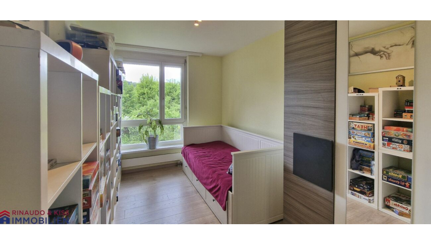 Kleines Zimmer mit Bett und Regalen