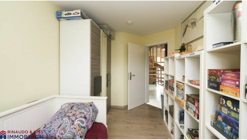 Kleines Zimmer mit Regalen und offener Tür