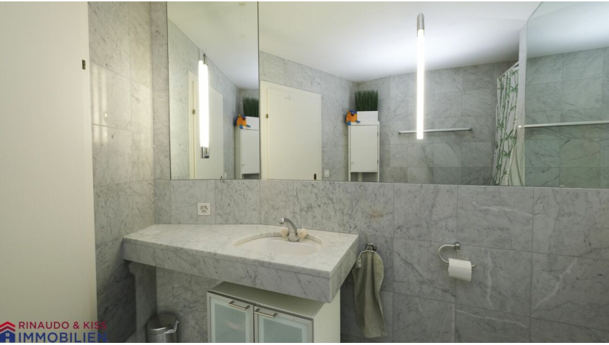 Modernes Badezimmer mit großem Spiegel und Betonoptik