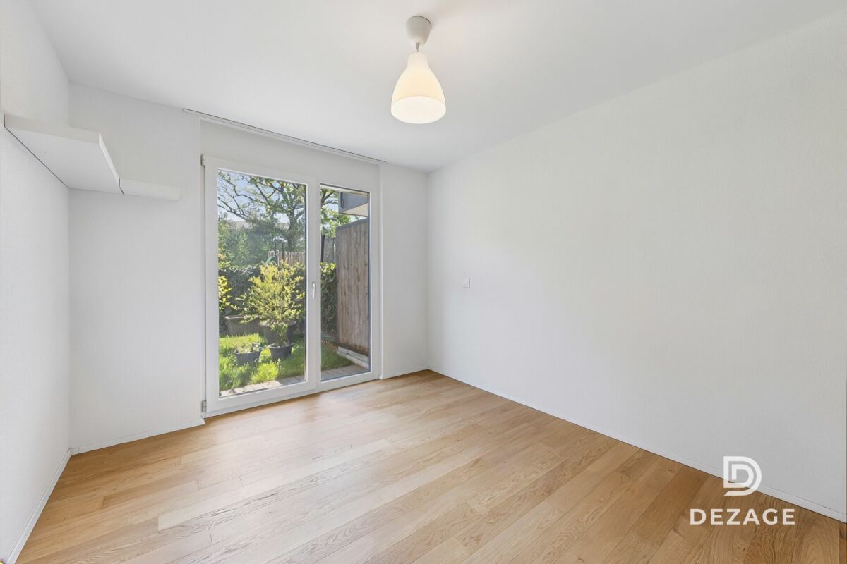 Heller leerer Raum mit Terrassentür und Gartenblick