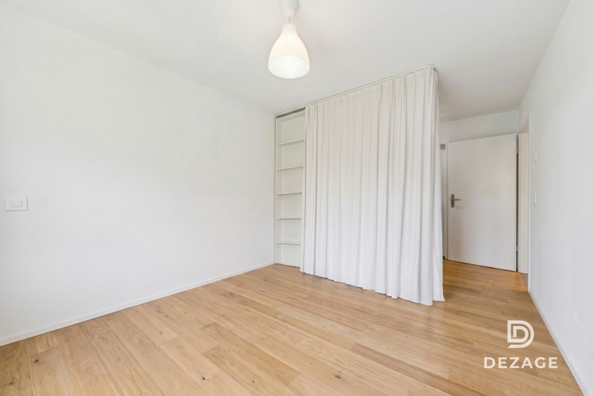 Helles, leer geräumtes Schlafzimmer mit Vorhangtrennung