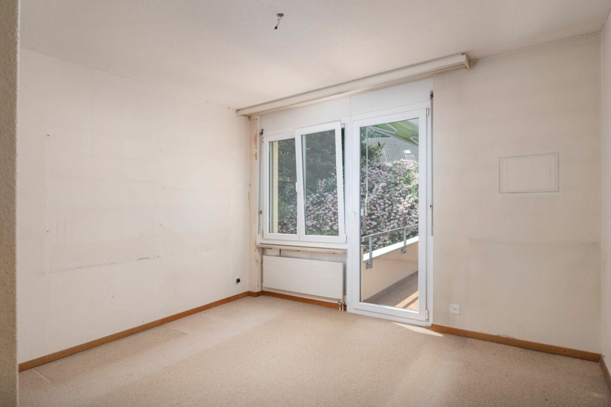 Leerer Wohnraum mit Balkonzugang
