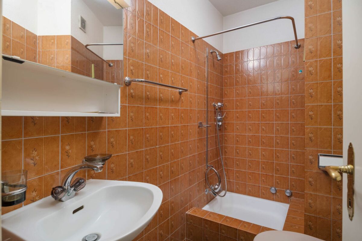 Orangefarbenes Badezimmer mit Badewanne und Waschtisch