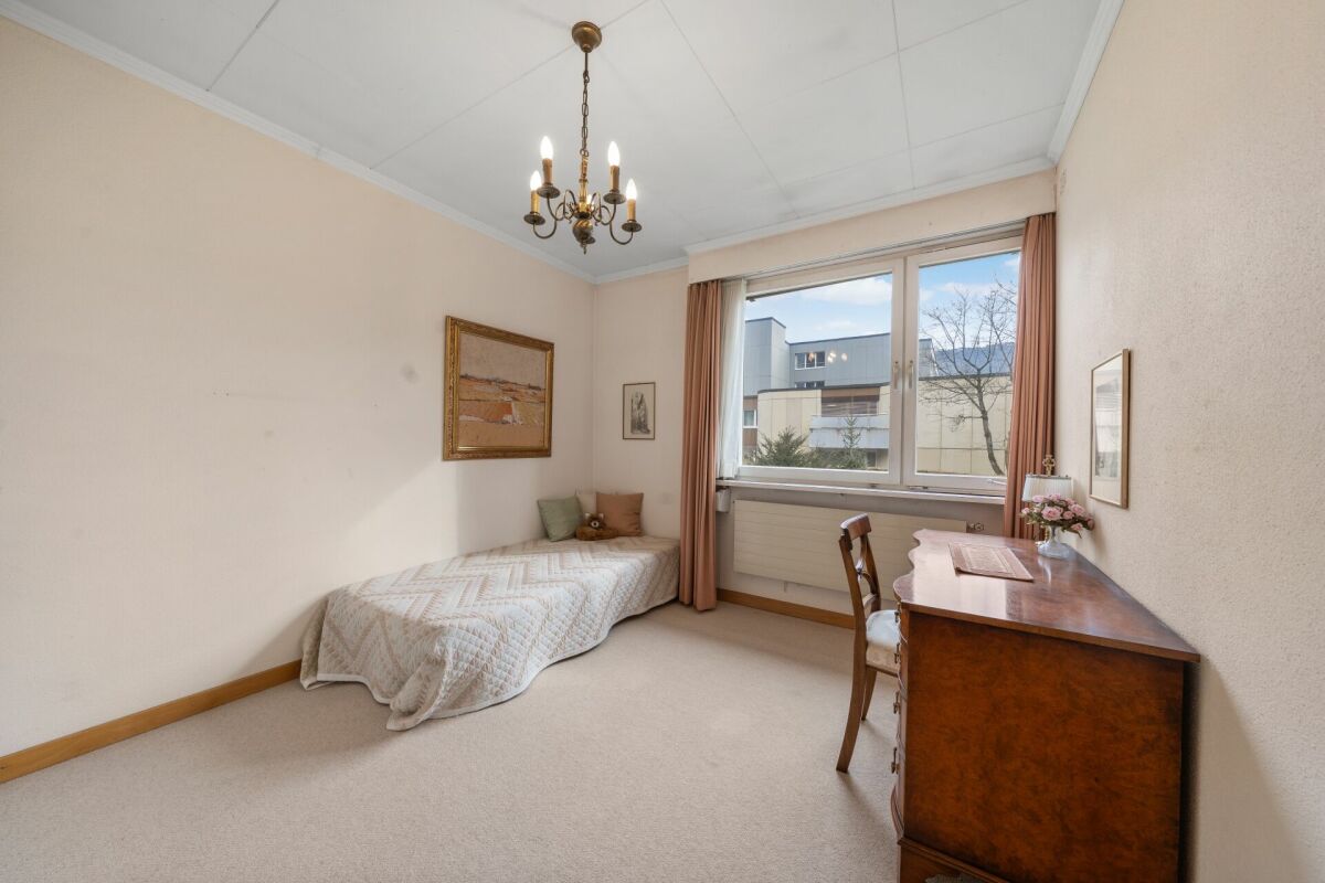 Helles Schlafzimmer mit Einzelbett und Schreibtisch