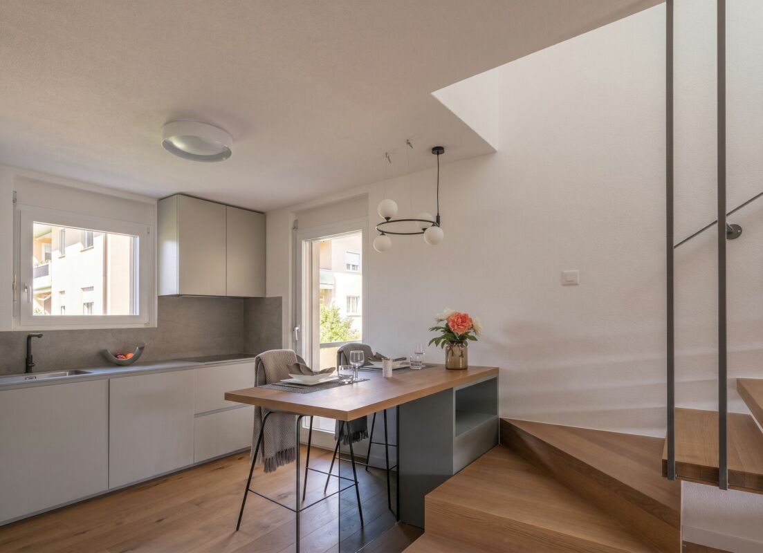 Offener Wohn- und Küchenbereich mit Esstisch und Treppe