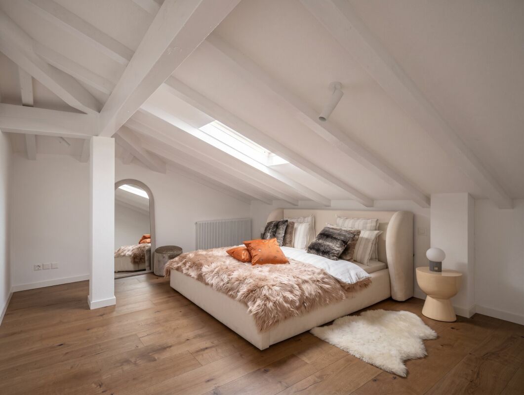 Dachgeschoss-Schlafzimmer mit sichtbaren Holzbalken
