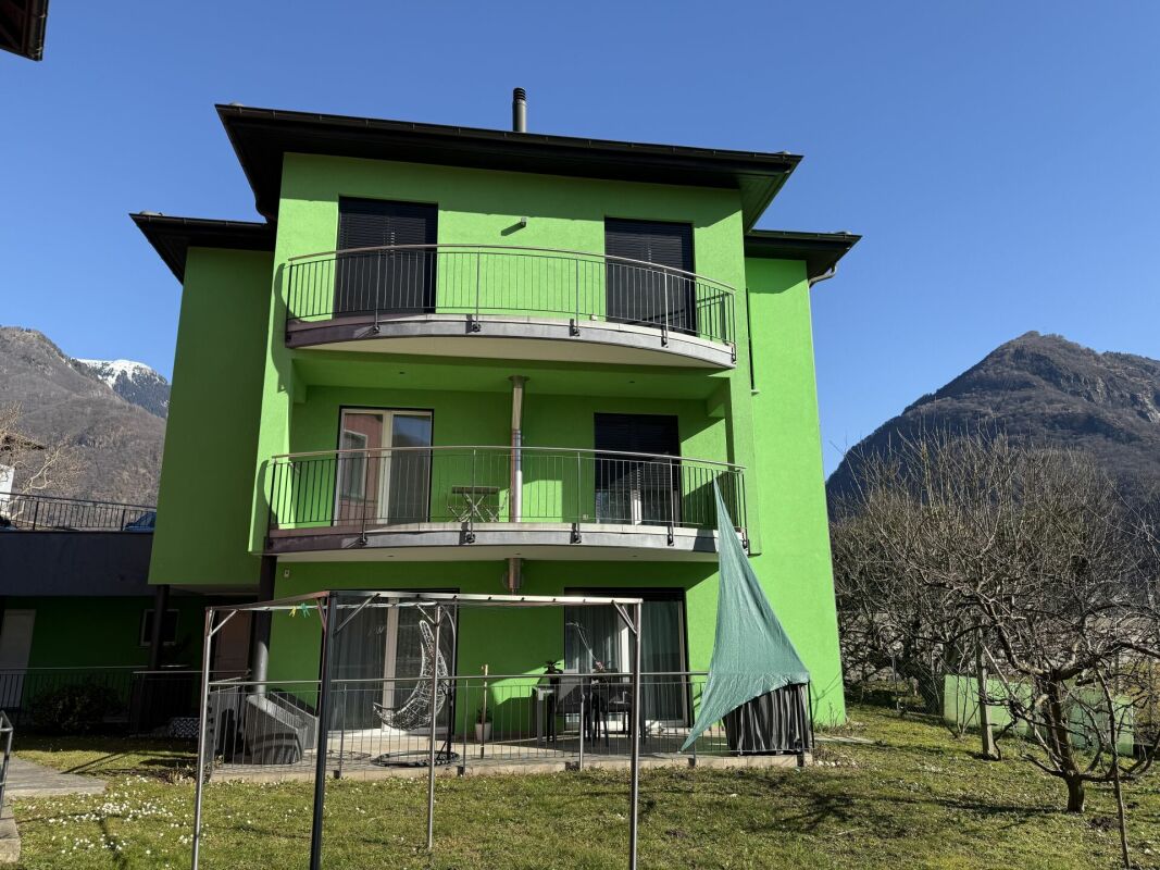 Grün gestrichenes Mehrfamilienhaus mit Balkonen