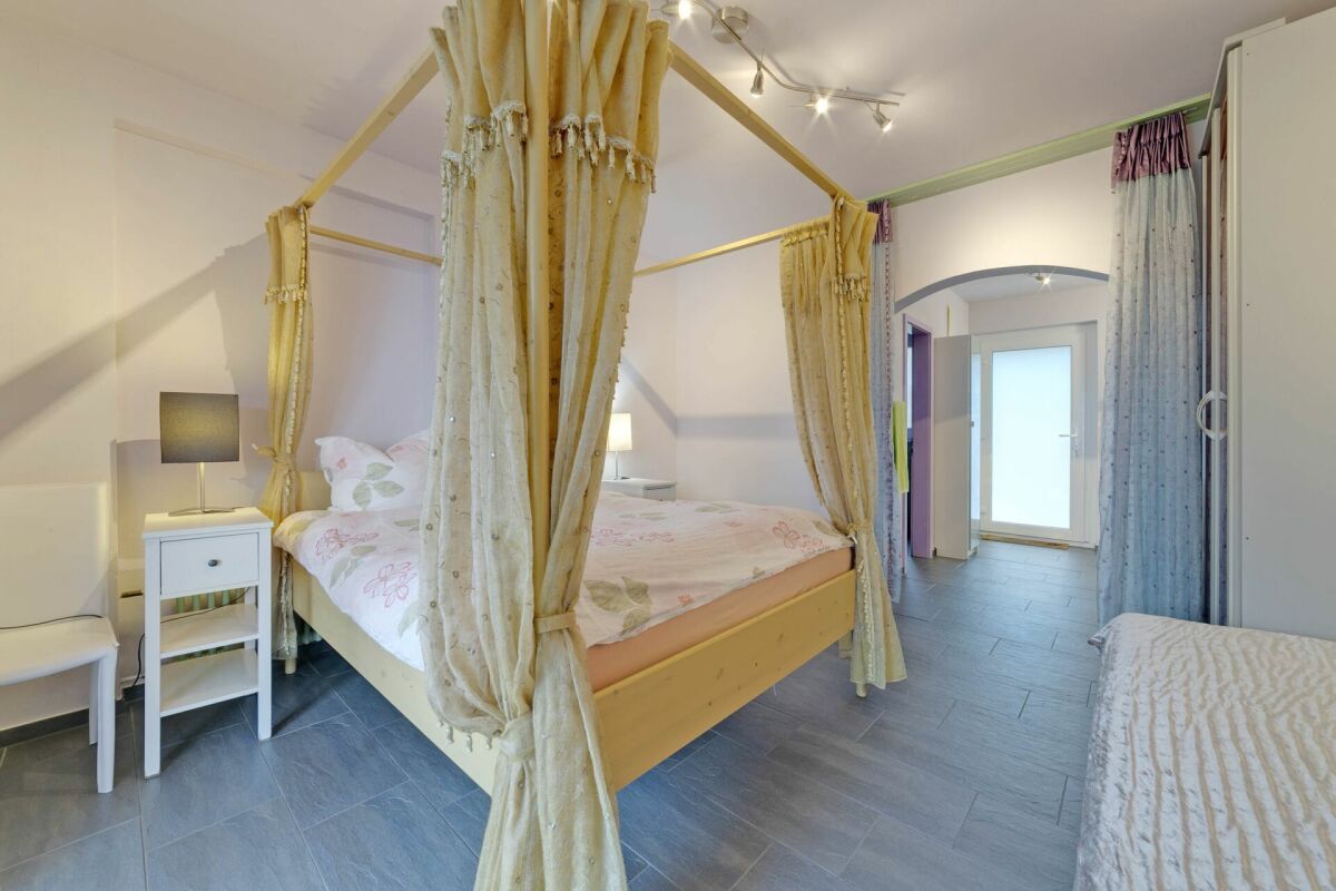 Schlafzimmer mit Himmelbett und Flurblick