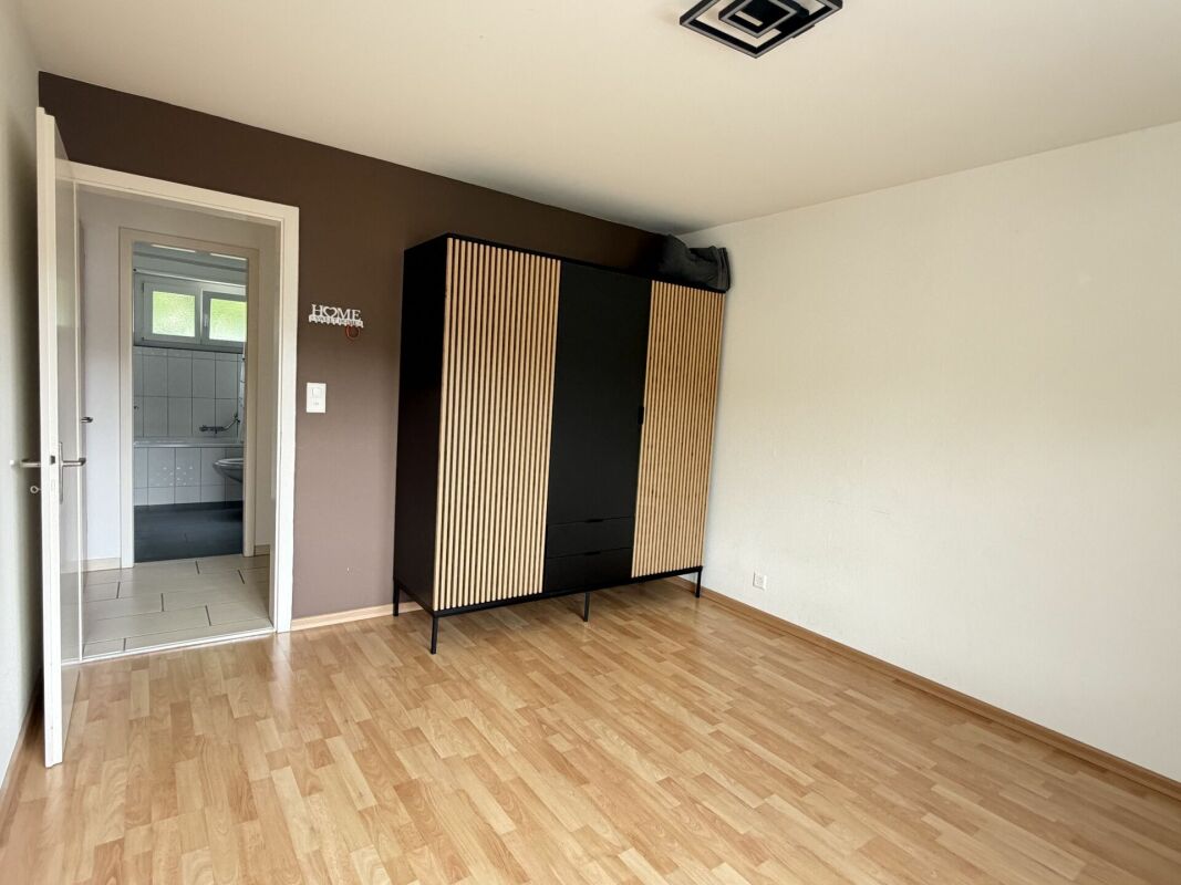 Leeres Schlafzimmer mit Schrank und Blick ins Bad