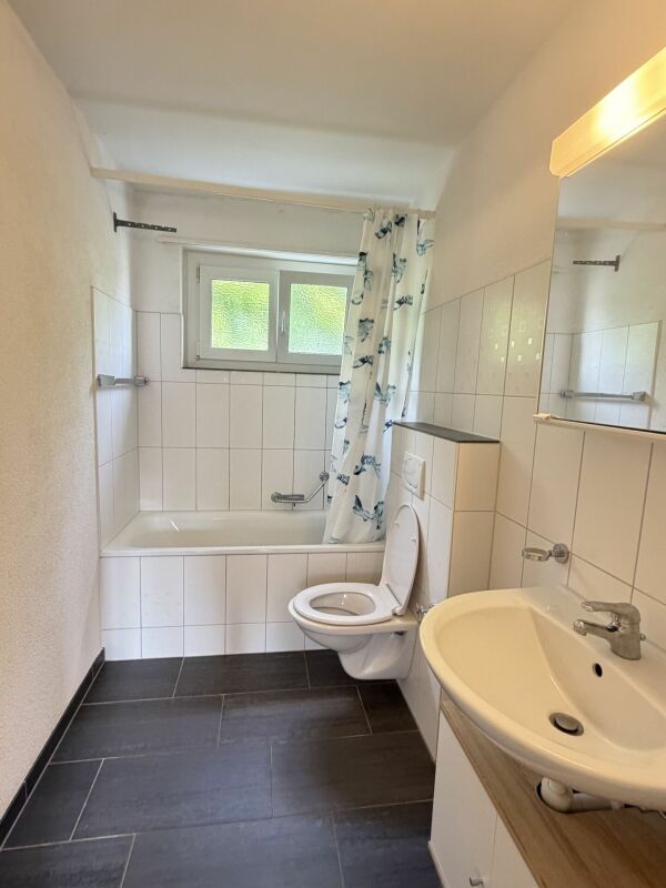 Badezimmer mit Badewanne, WC und Waschbecken