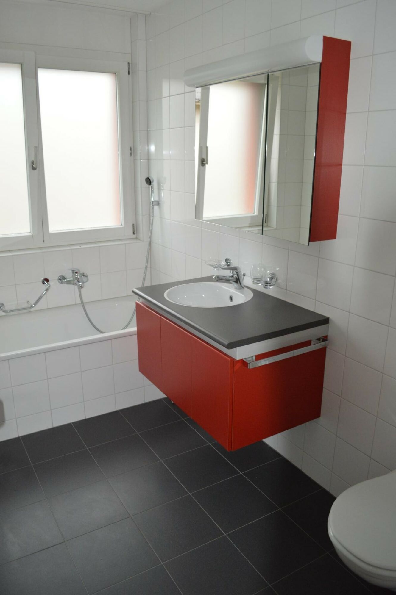 Modernes Badezimmer mit rot-weißem Waschtisch