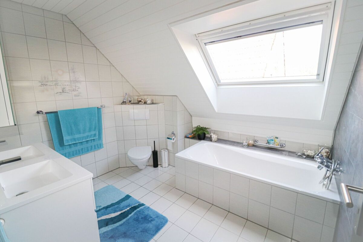 Modernes Dachgeschossbad mit Badewanne und Velux-Fenster