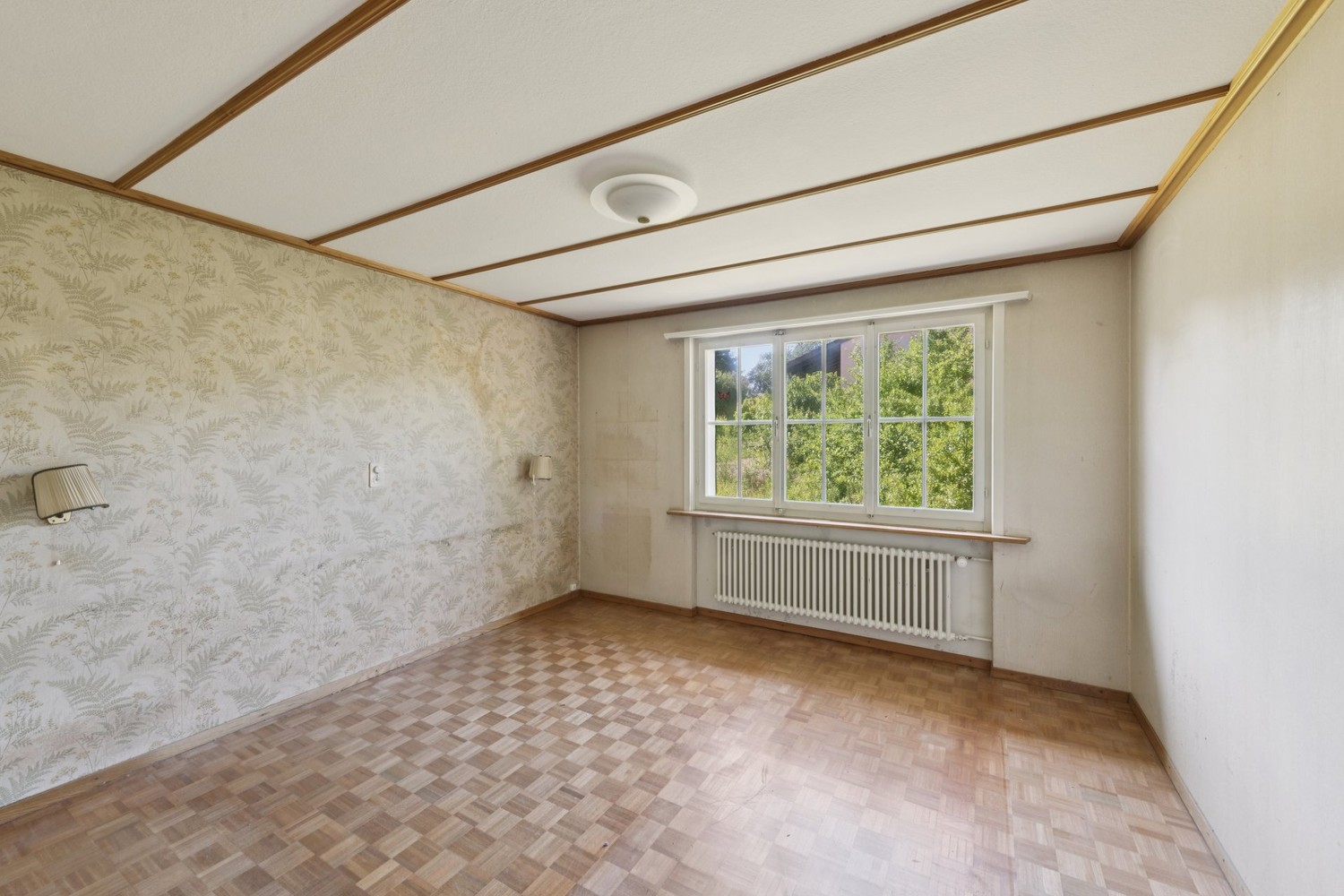 Leerer Wohnraum mit Fenster und Tapete