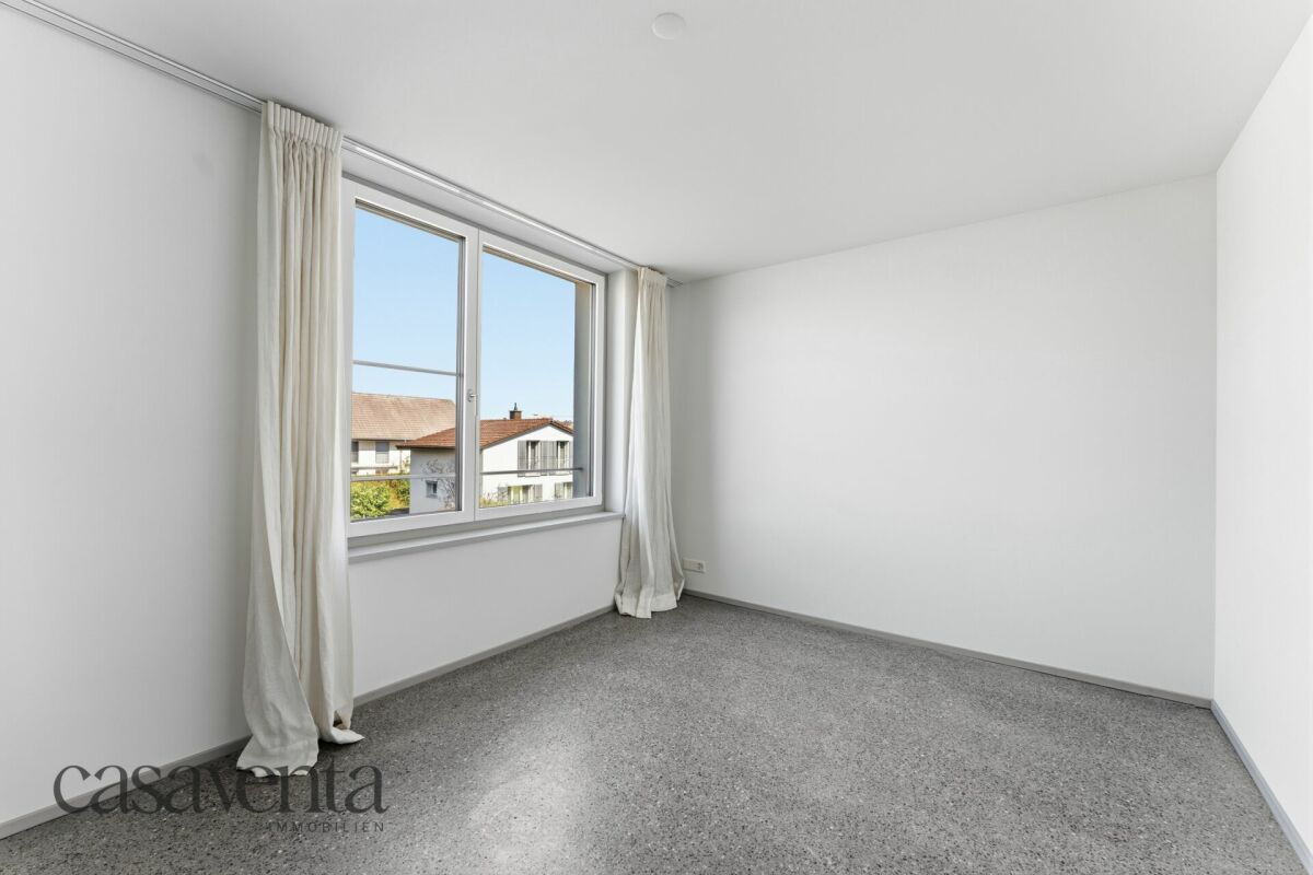 Helles, leeres Zimmer mit großem Fenster