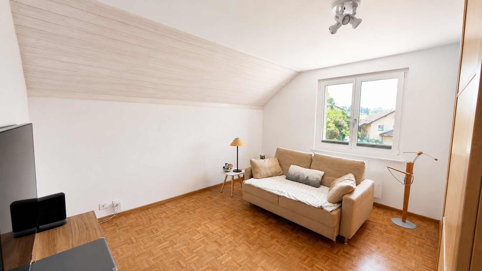 Helles Dachzimmer mit Sofa und Fenster