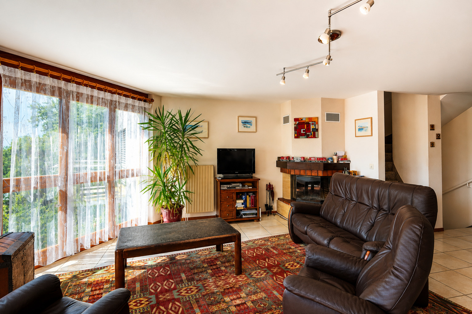 Helles Wohnzimmer mit Kamin und großen Fenstern