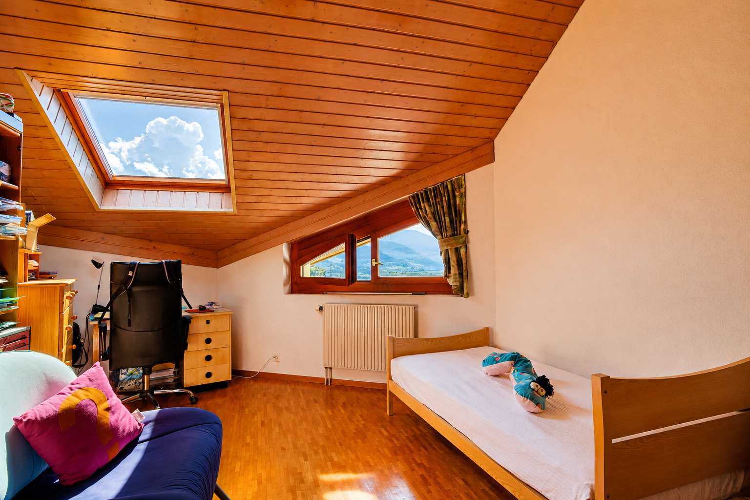 Dachgeschoss-Schlafzimmer mit Arbeitsbereich und Dachfenstern