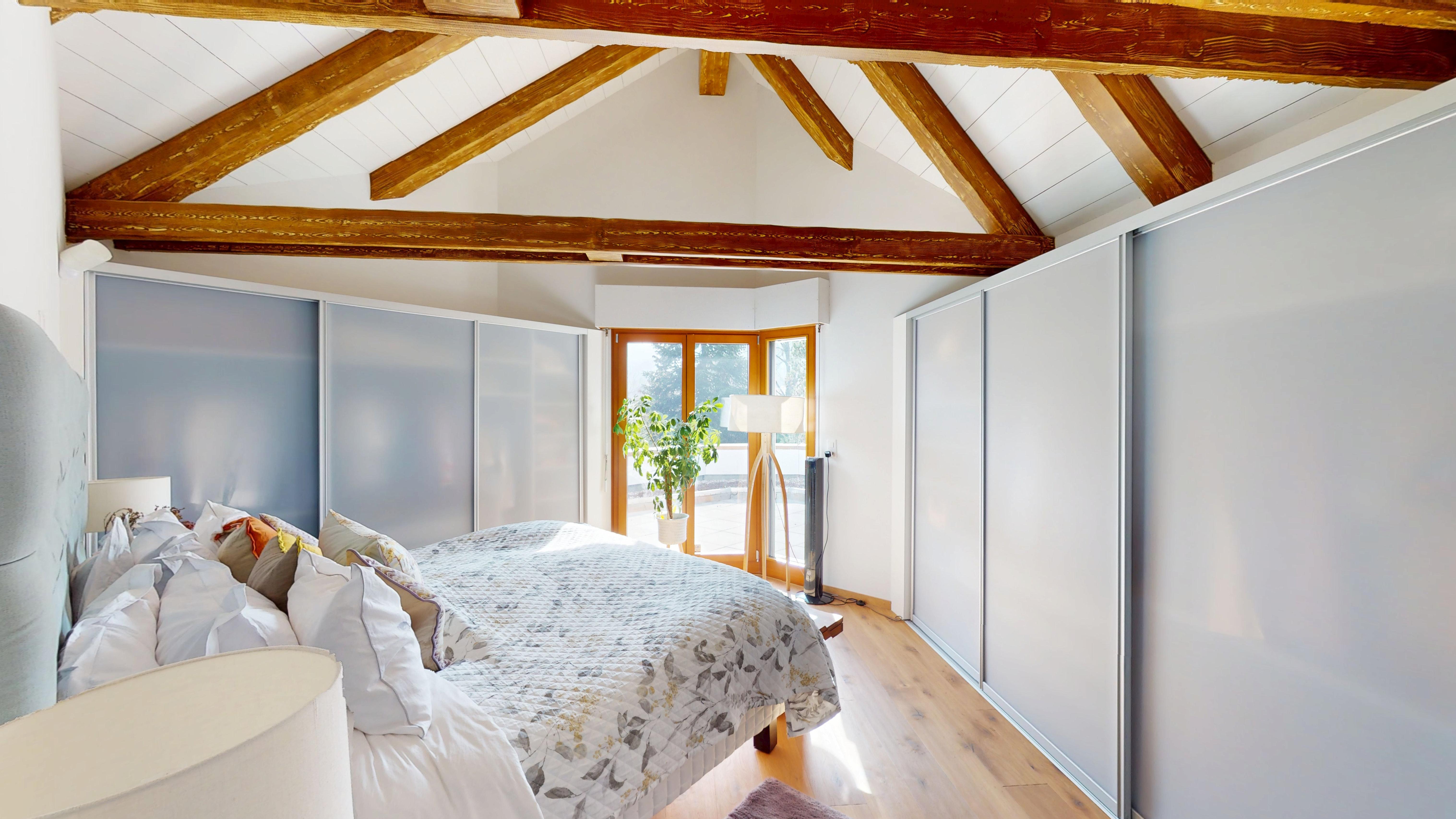 Helles Schlafzimmer mit sichtbaren Holzbalken