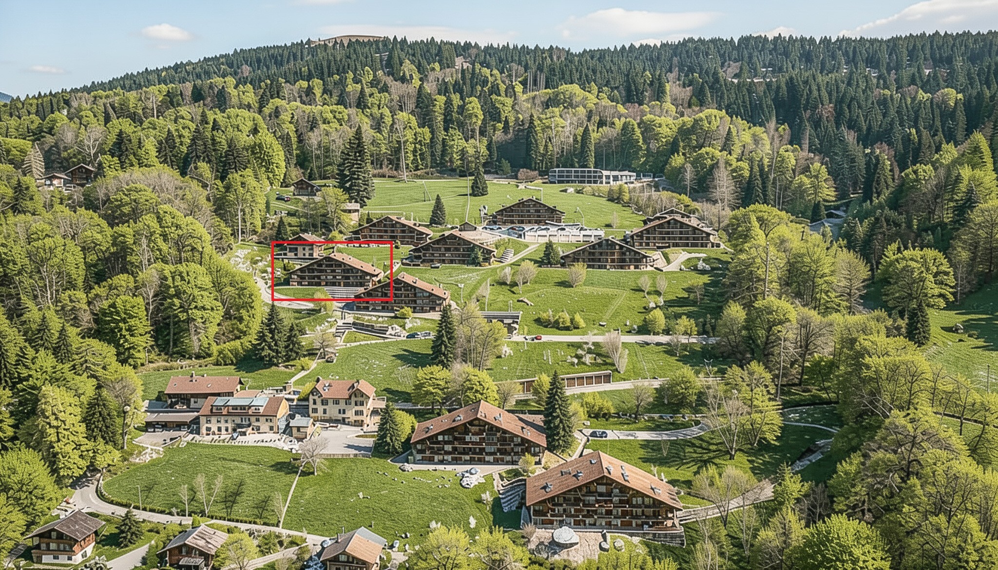 Luftaufnahme eines weitläufigen Ferienresorts in bergiger Waldlandschaft