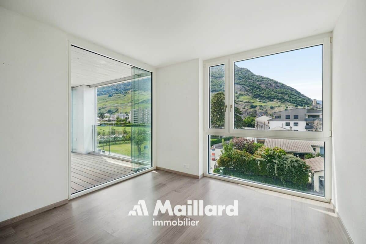 Heller Wohnraum mit Balkon und Bergblick