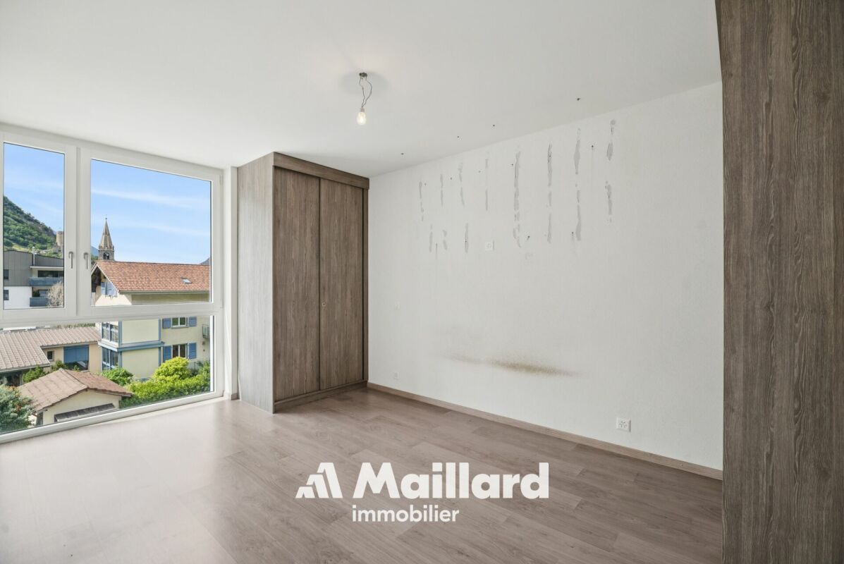 Helles leeres Schlafzimmer mit großem Fenster und Einbauschrank