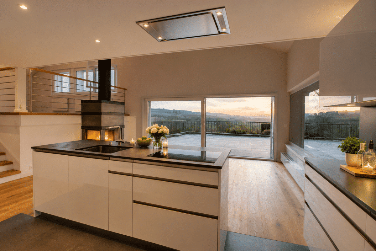 Offene Wohnküche mit Kamin und Terrasse