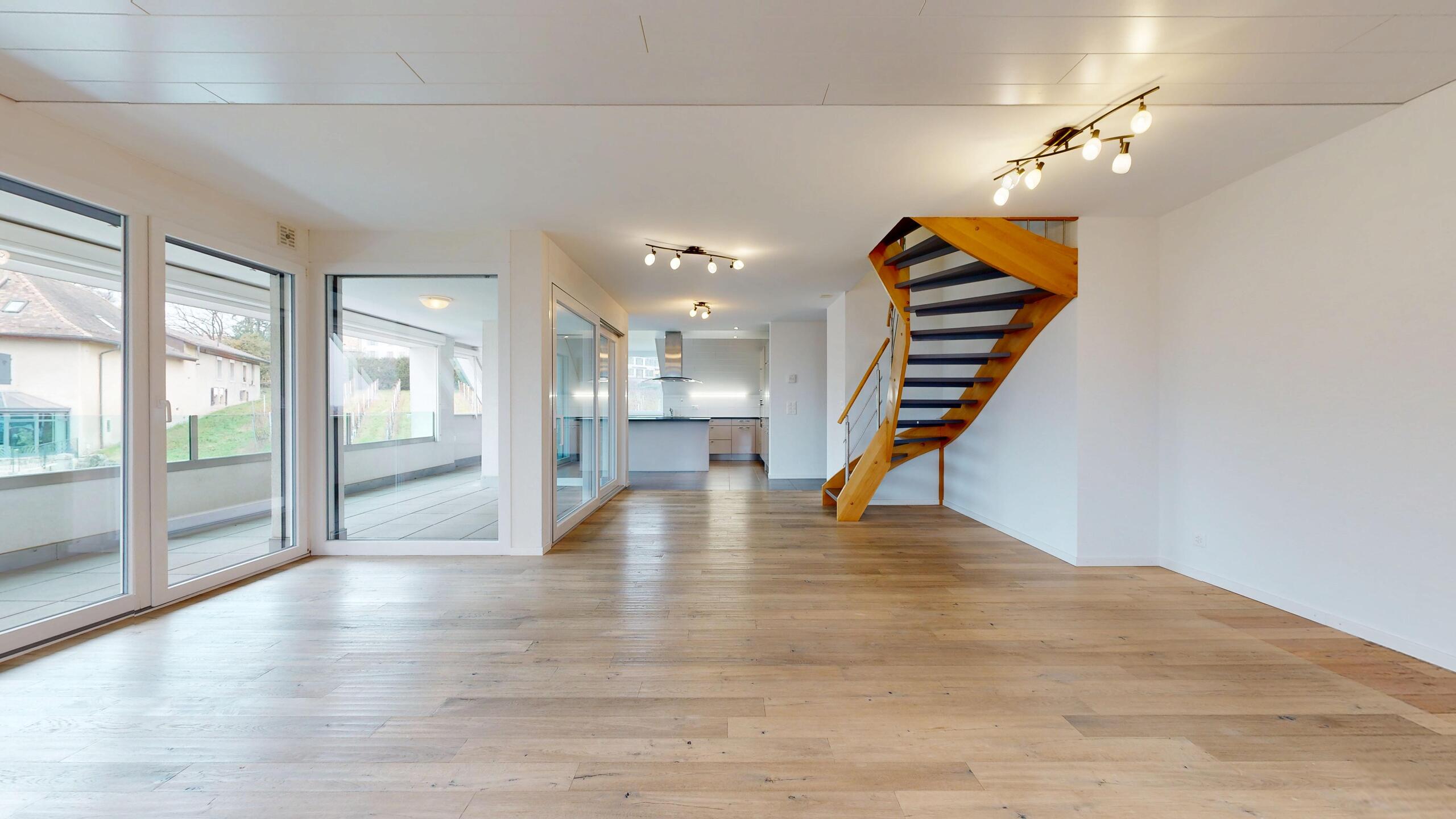 Heller Wohnbereich mit Treppe und Fensterfront