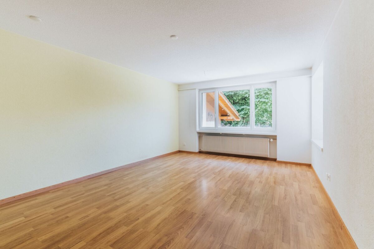 Leerer, heller Wohnraum mit Holzoptikboden