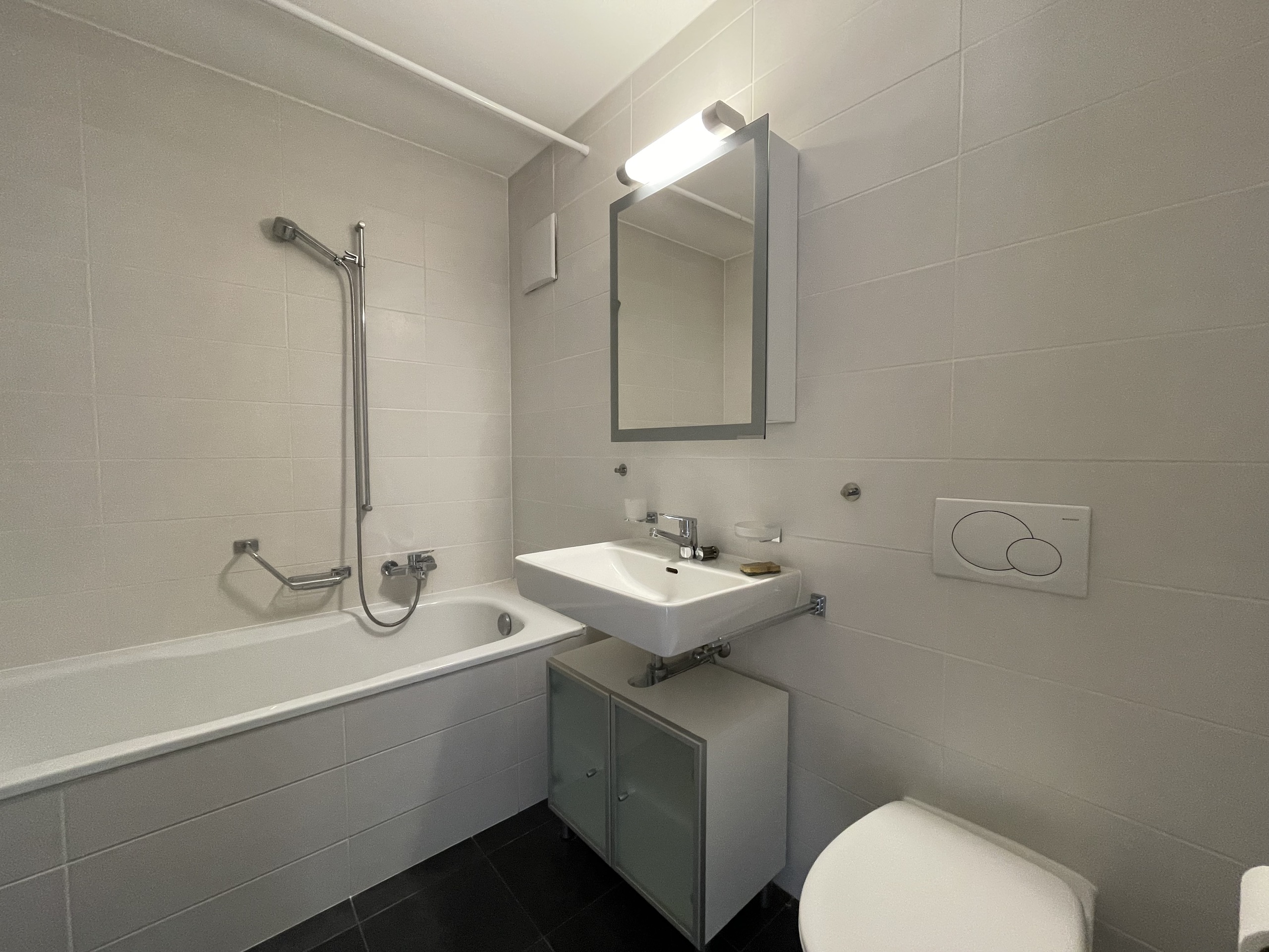 Modernes Badezimmer mit Badewanne, Waschtisch und WC