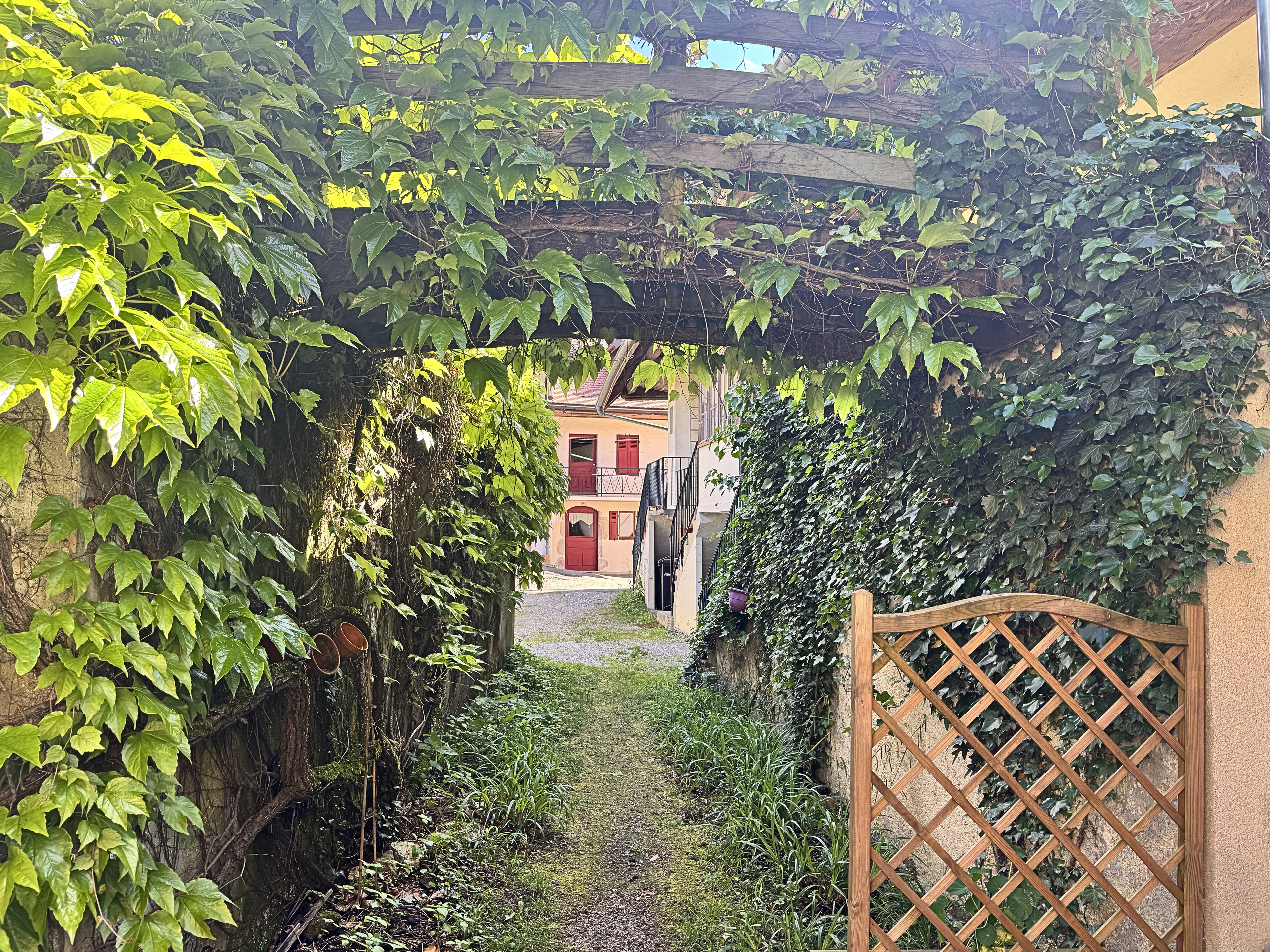 Überwachsener Außenweg mit Torbogen