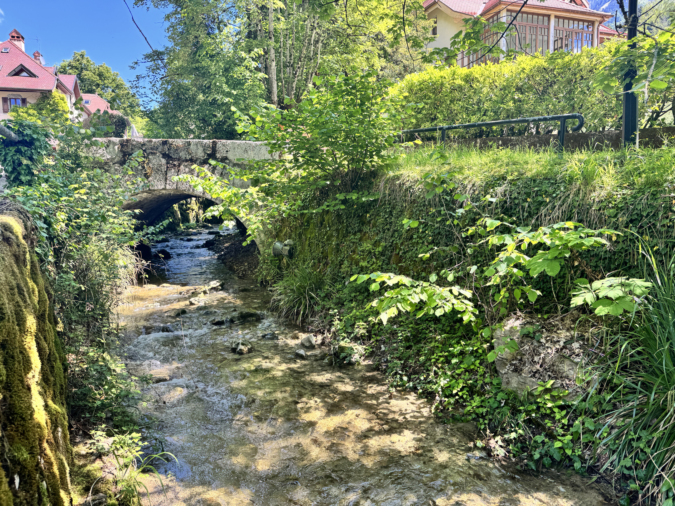 Bachlauf unter einer Steinbrücke im Grünen