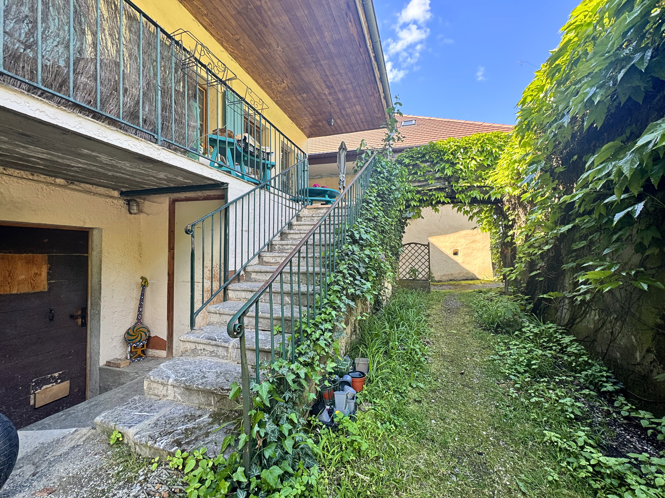 Verwachsener Innenhof mit Treppe und Balkon