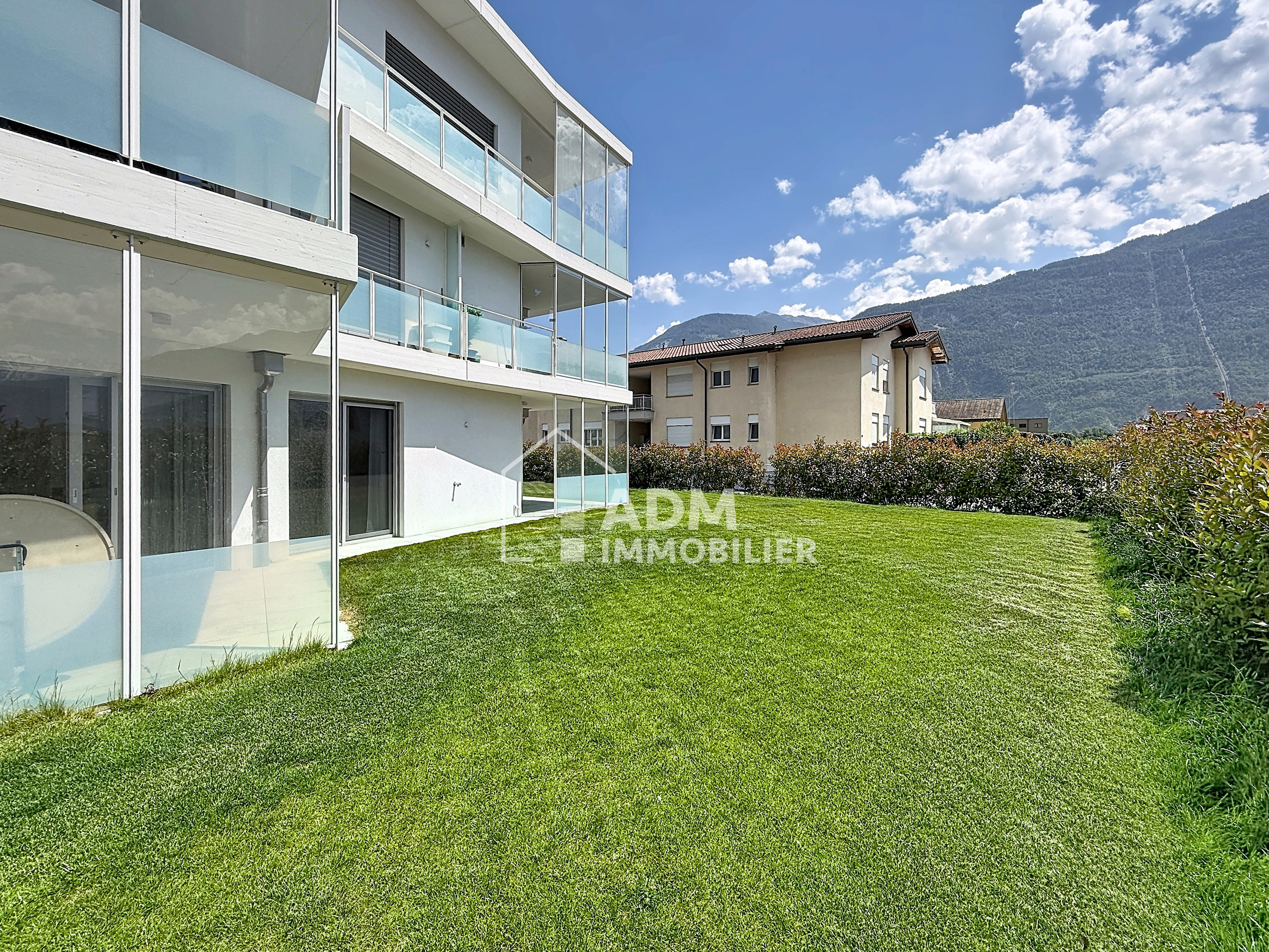 Moderne Wohnanlage mit Garten und Bergblick