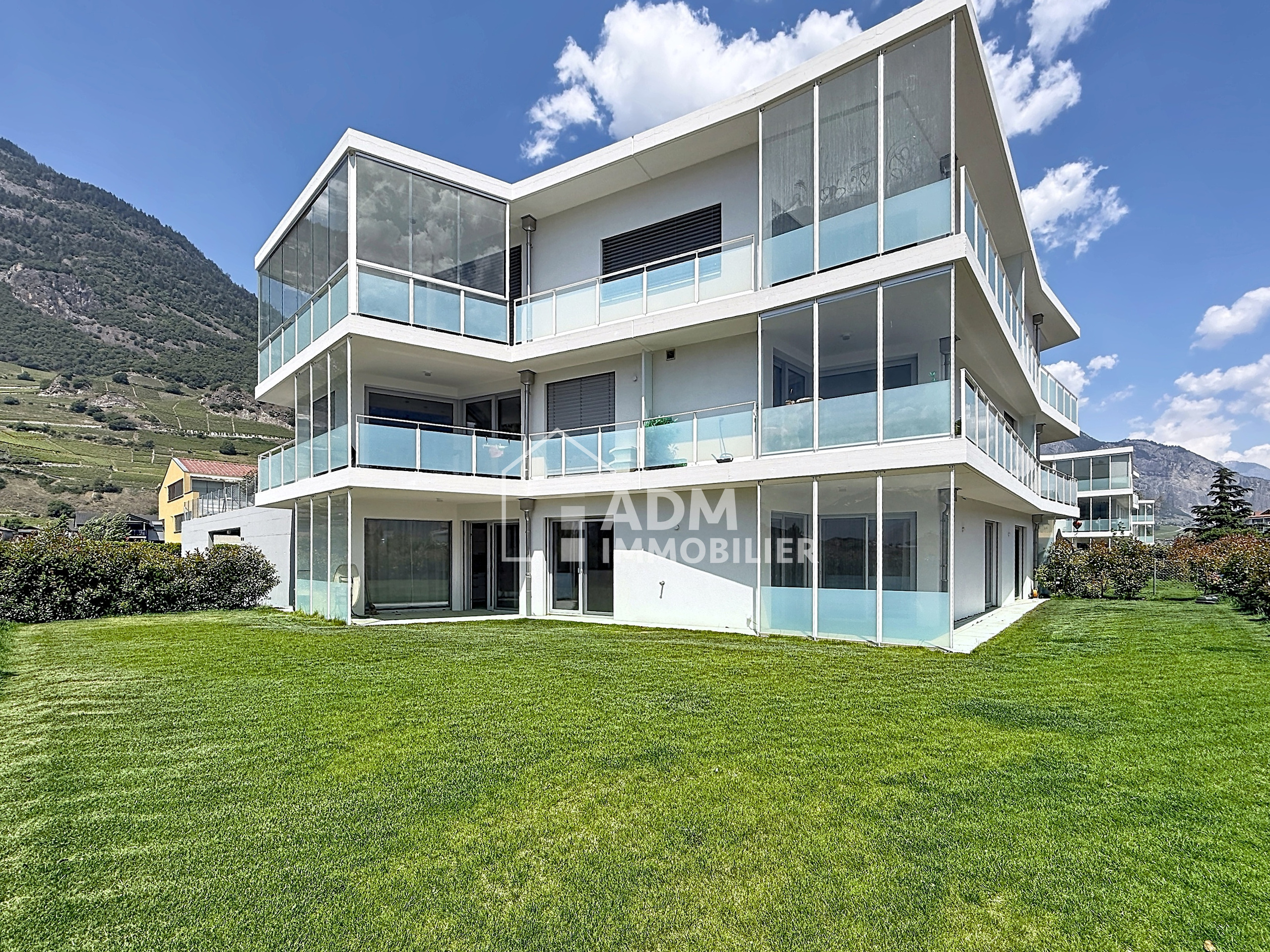 Modernes Mehrfamilienhaus mit großen Glasbalkonen