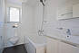 Helles Badezimmer mit Wanne und Fenster