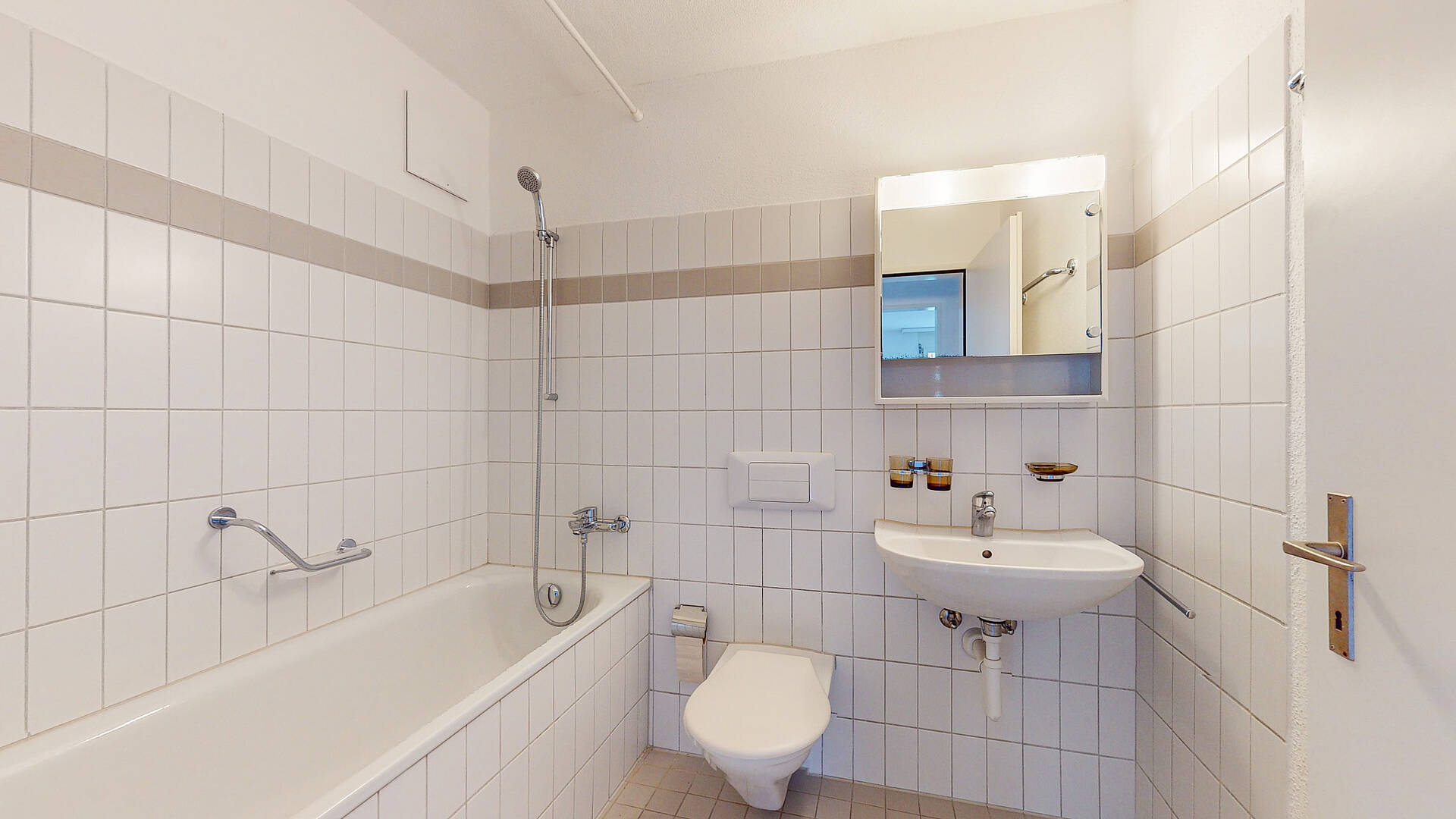 Kleines helles Badezimmer mit Wanne, WC und Waschbecken