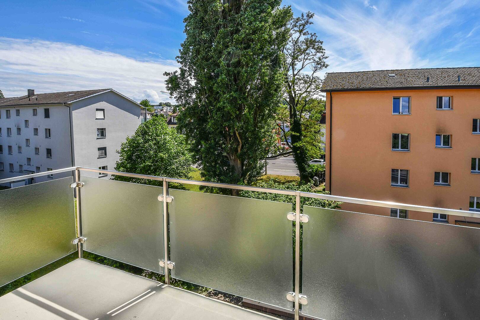Balkon mit Blick auf Wohnhäuser und Bäume