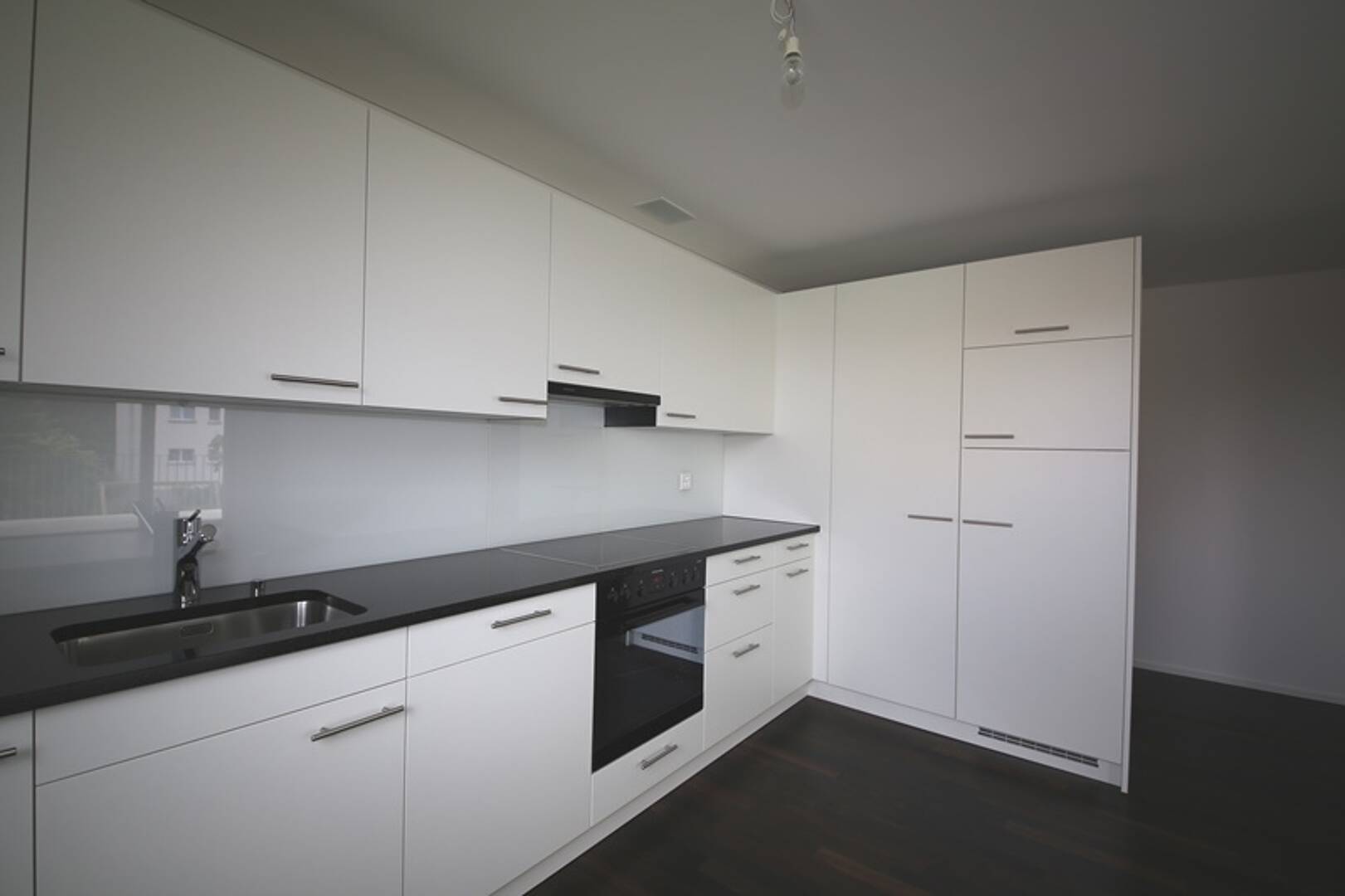 Moderne weiße Küche mit dunkler Arbeitsplatte