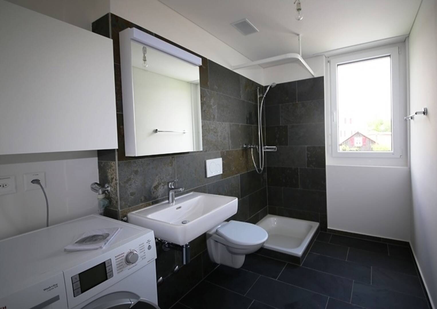 Modernes Badezimmer mit Dusche, Waschbecken und Waschmaschine