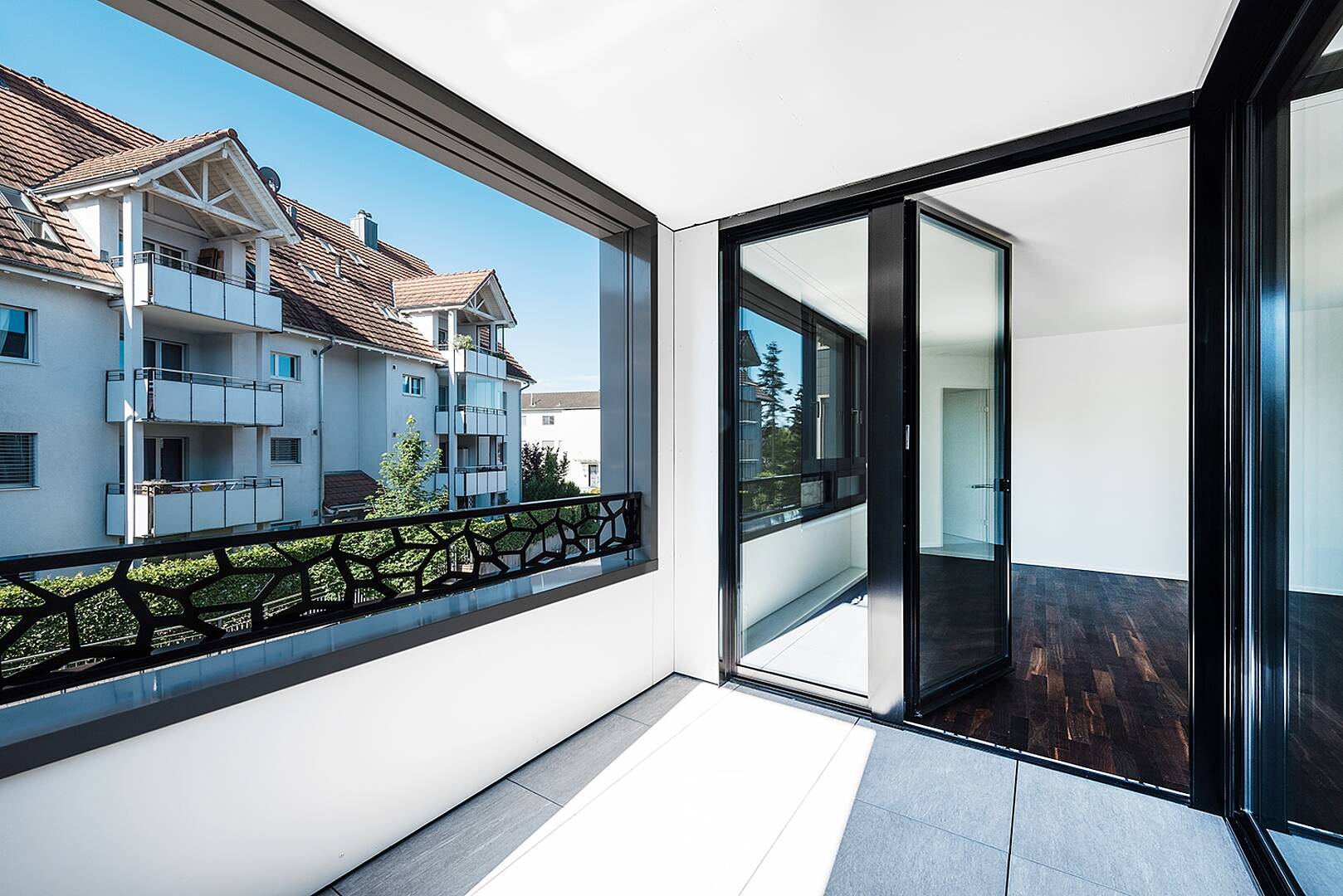 Heller Balkon mit Blick auf ein Wohngebäude