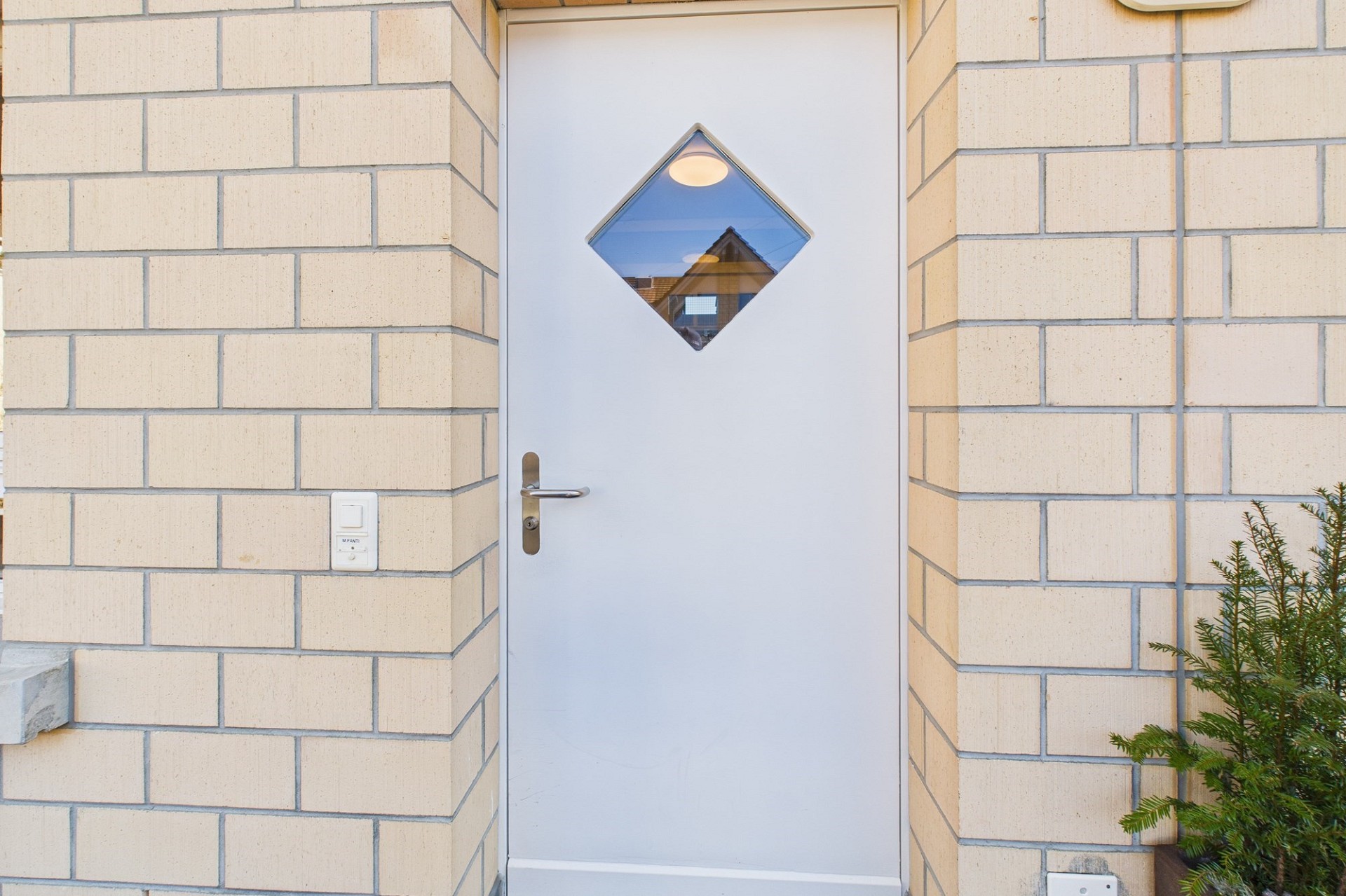 Weiße Eingangstür mit Diamantfenster