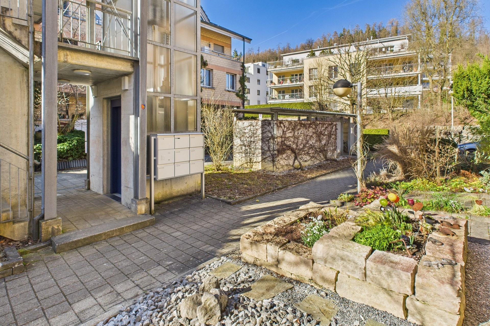 Außenansicht eines Wohngebäudes mit Innenhof und Gartenweg