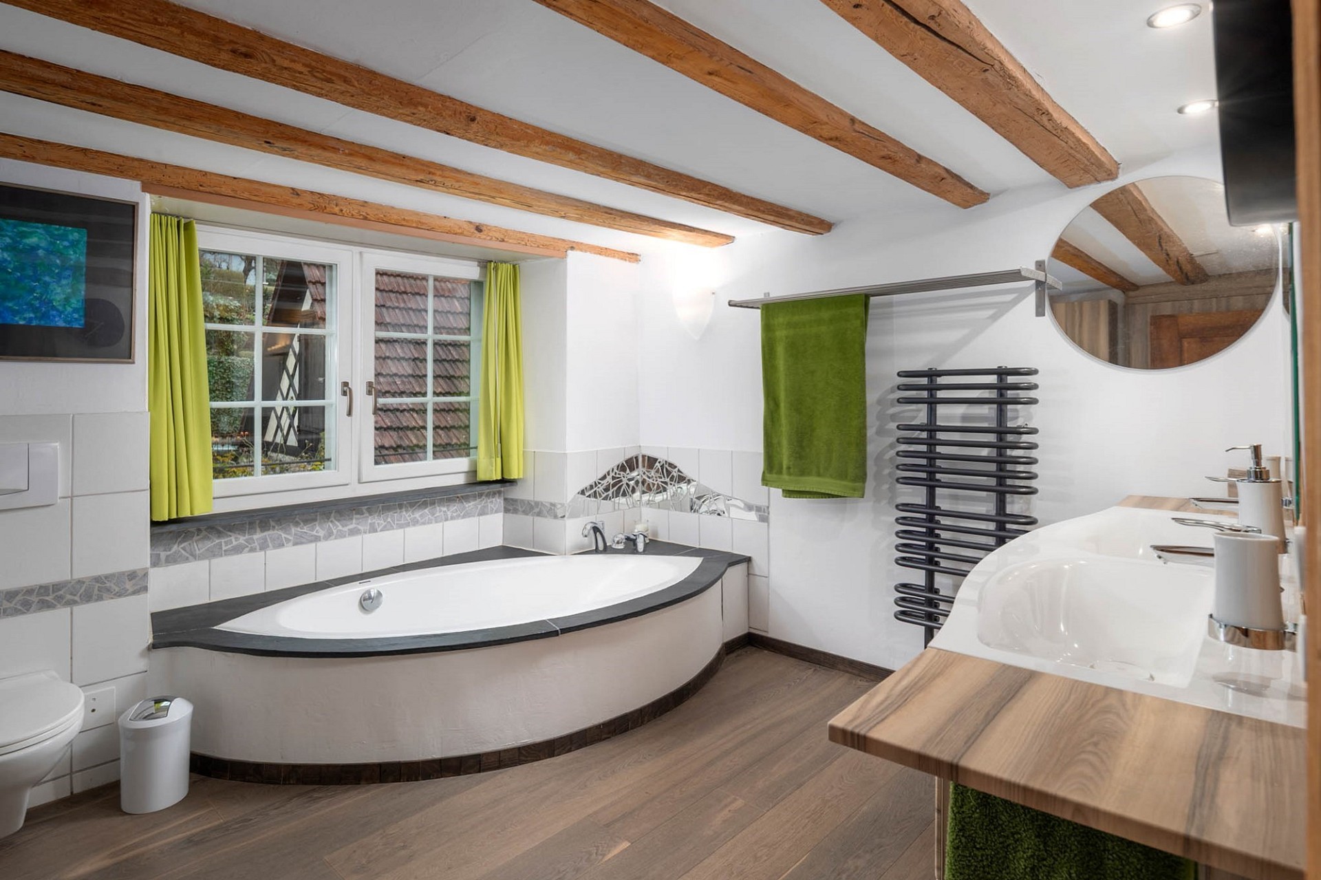 Helles Badezimmer mit freistehender Wanne und Holzdeckenbalken