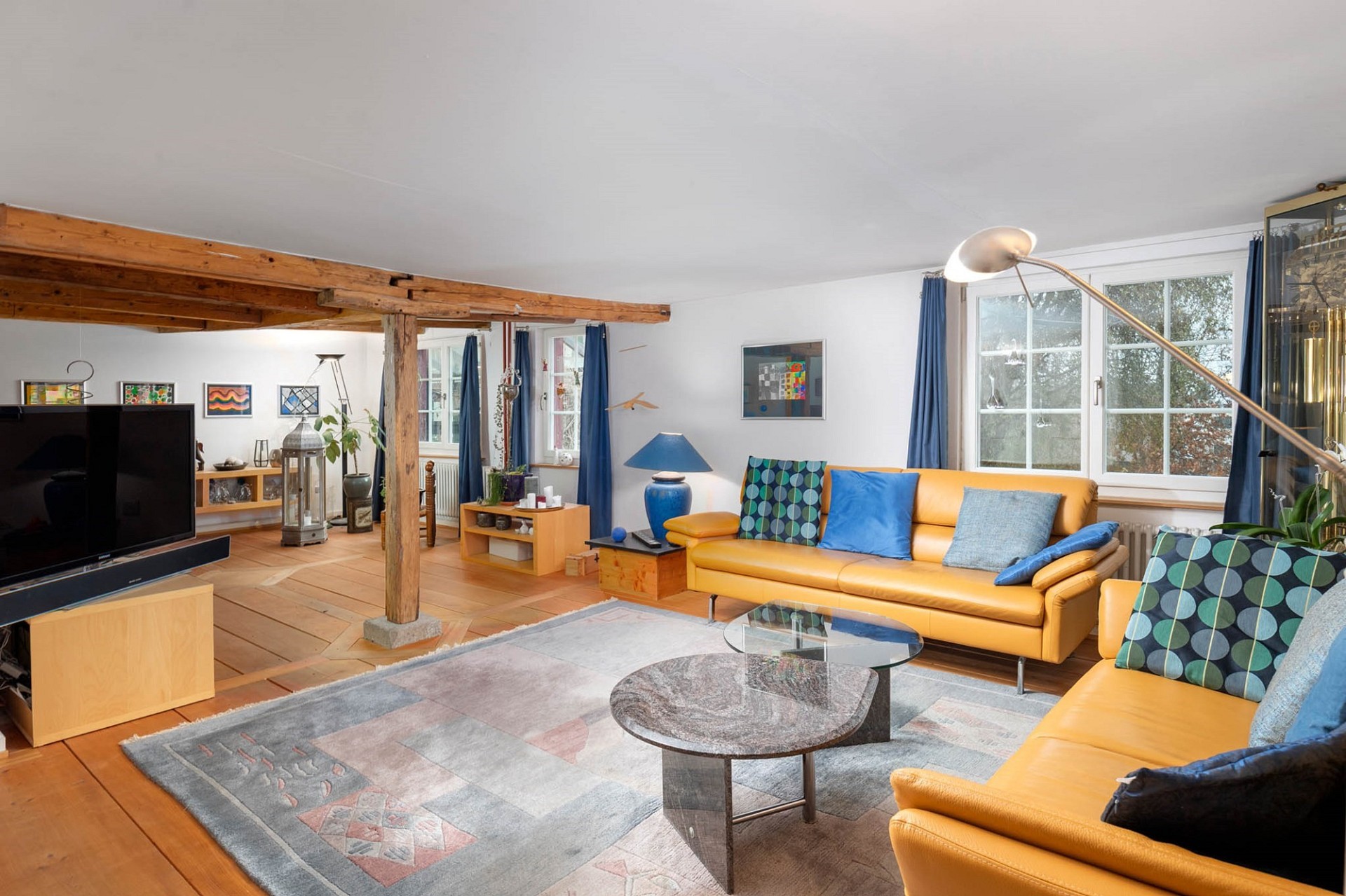Helles Wohnzimmer mit Holzdecke und gelbem Sofa