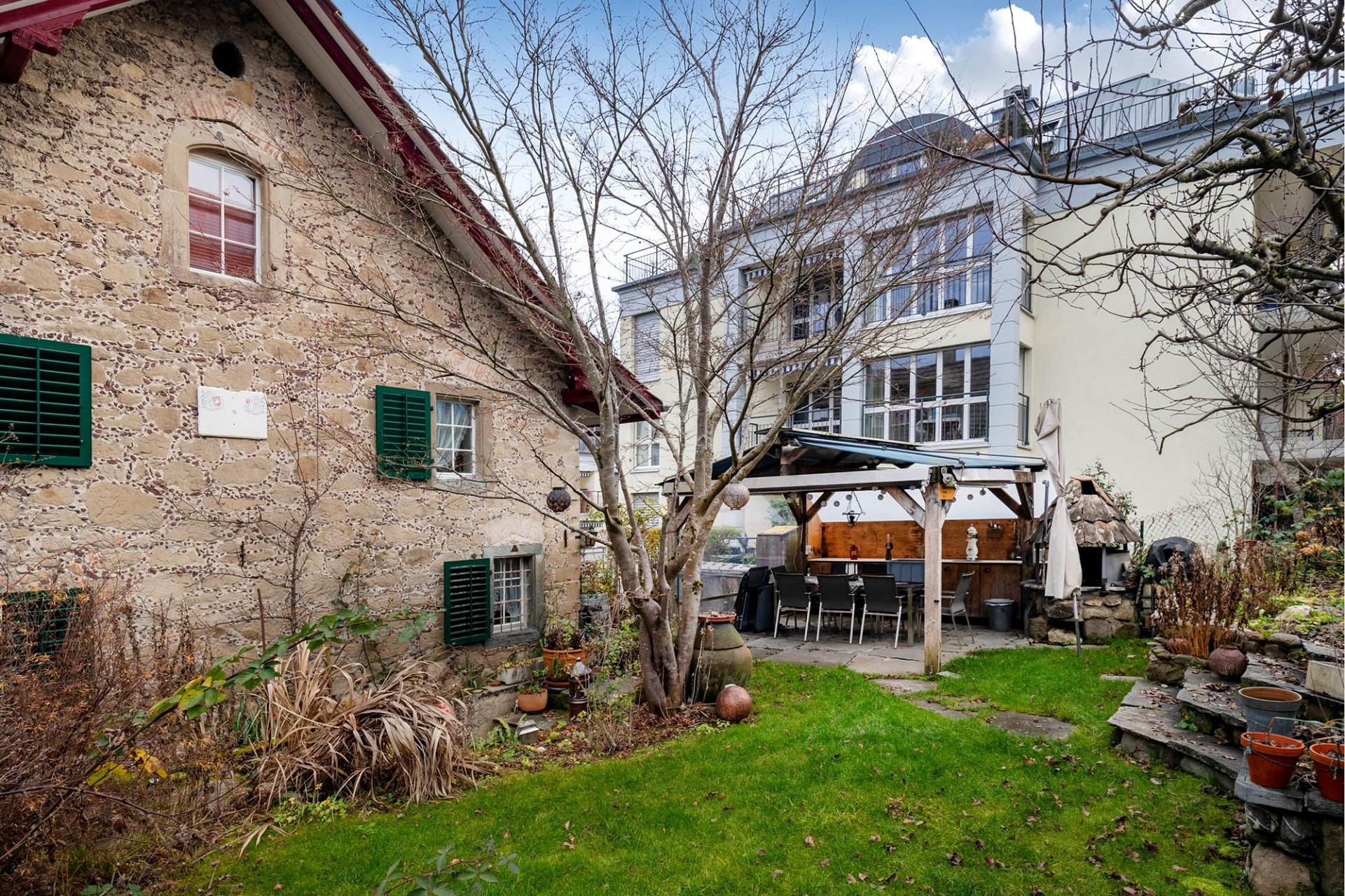 Innenhof mit historischem Steinhaus und Gartenpavillon
