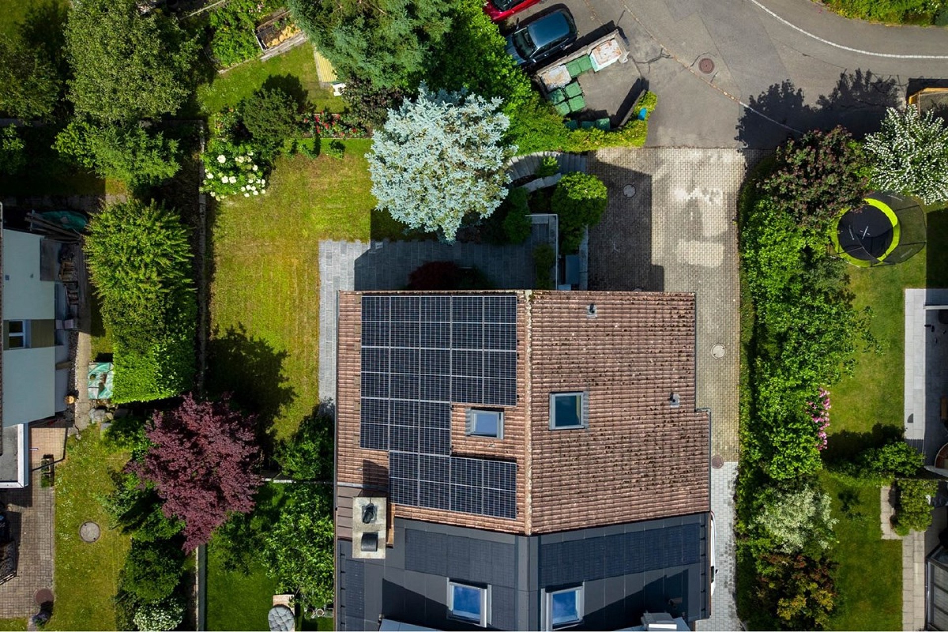 Drohnenaufnahme eines Hauses mit Solardach und Garten