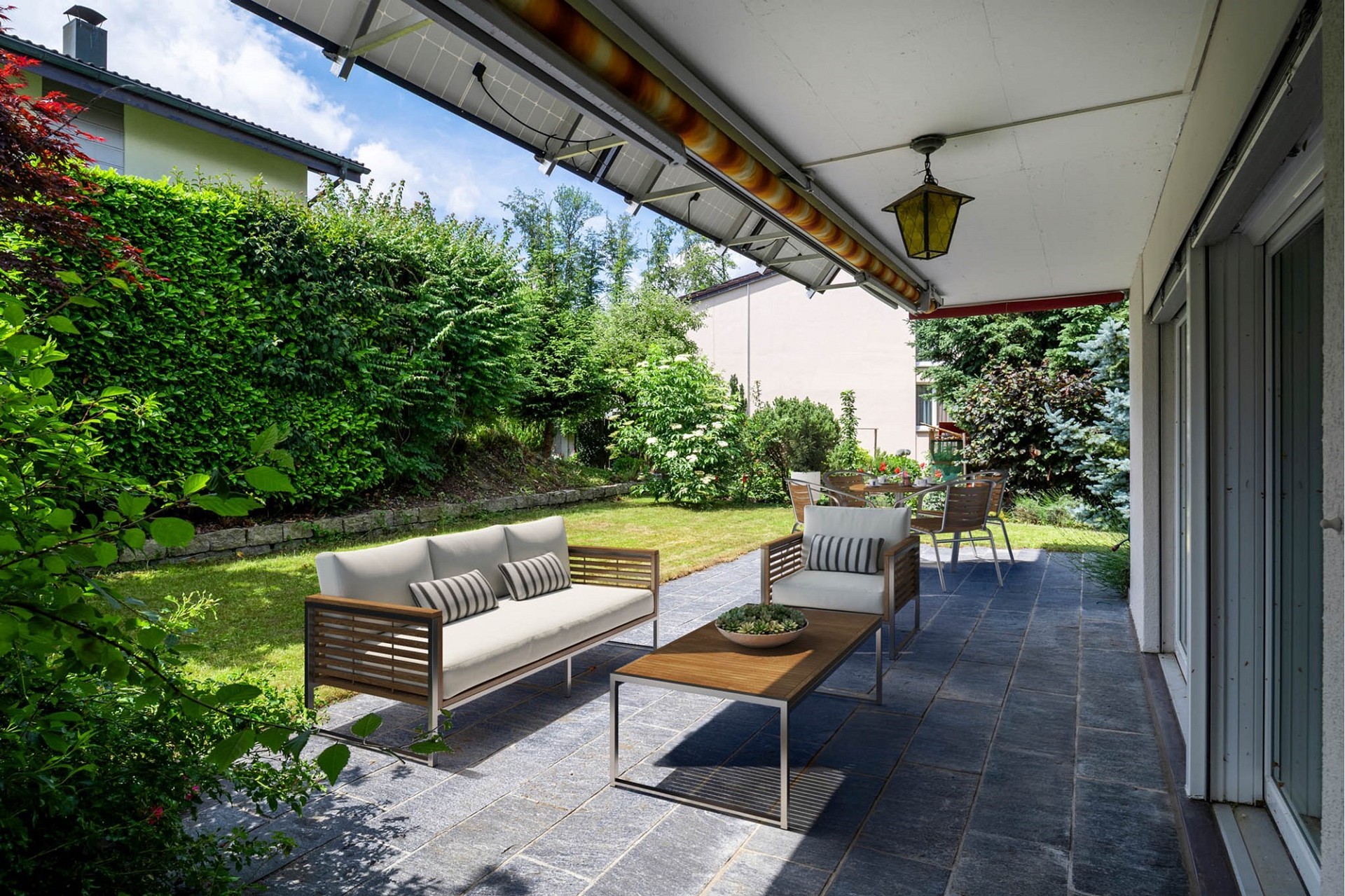 Überdachte Terrasse mit Gartenblick
