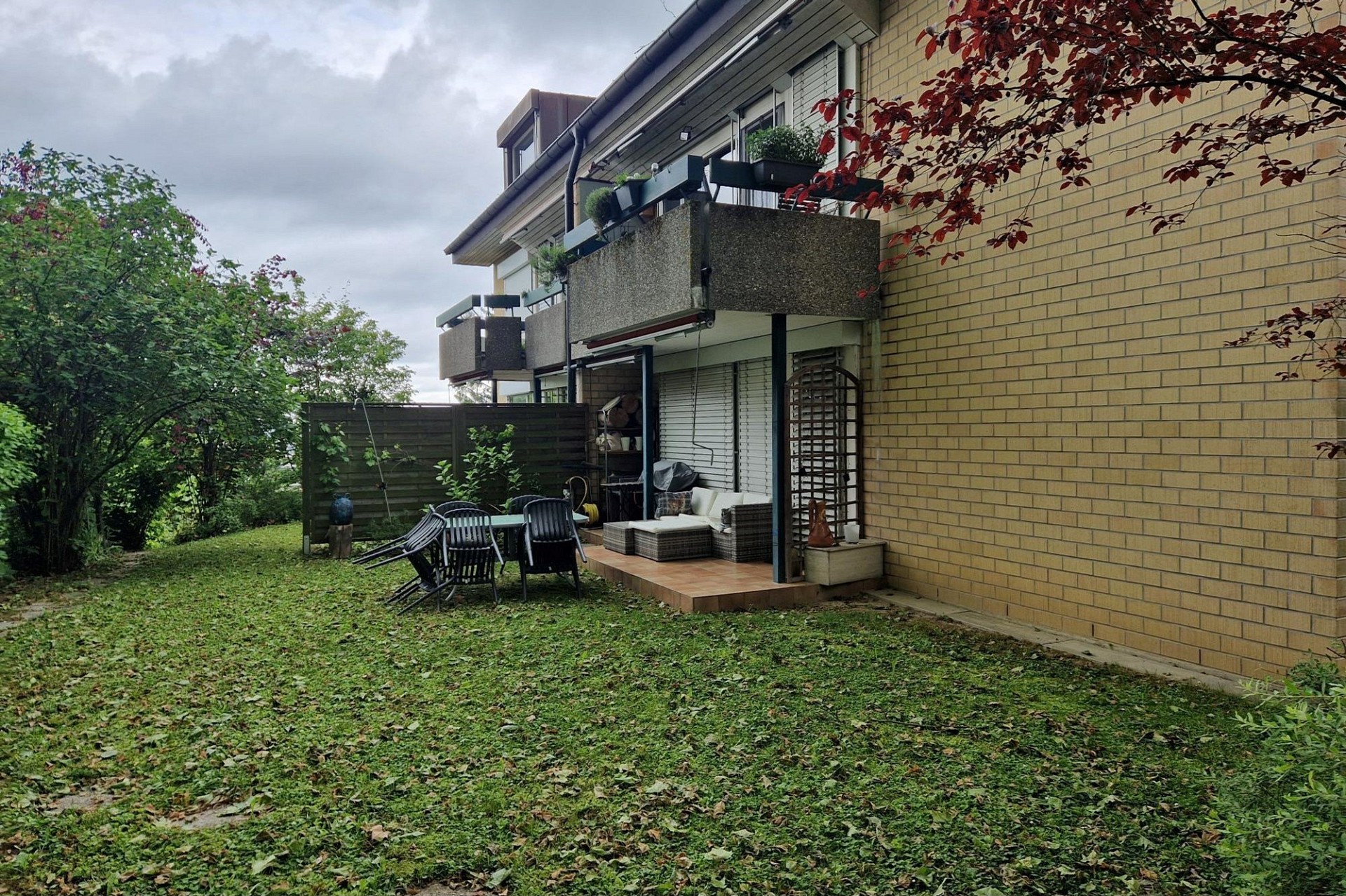Gartenansicht mit Terrasse und Balkon