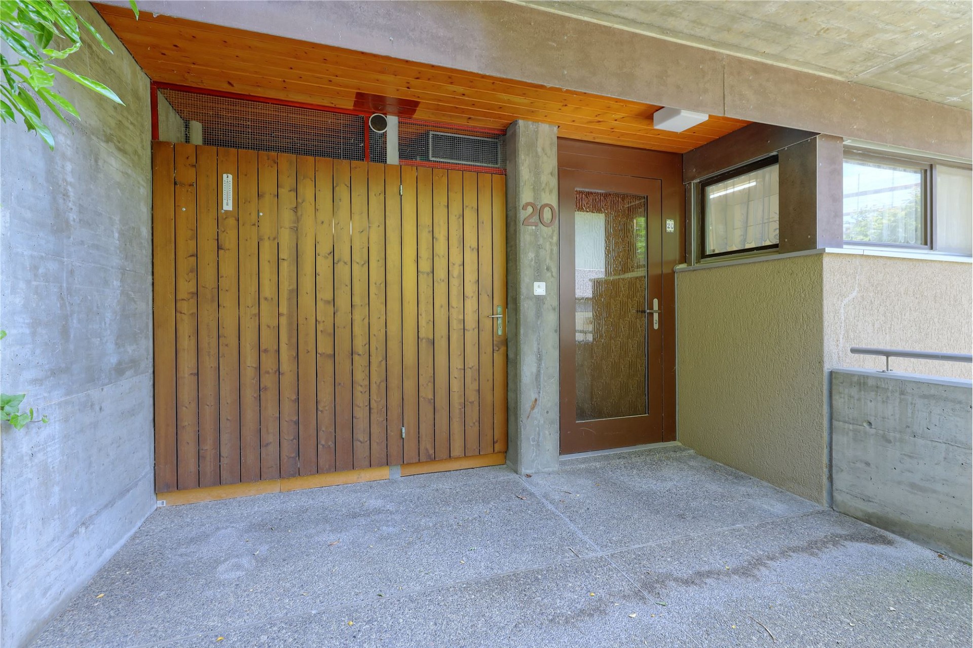 Überdachter Hauseingang mit Holzportal