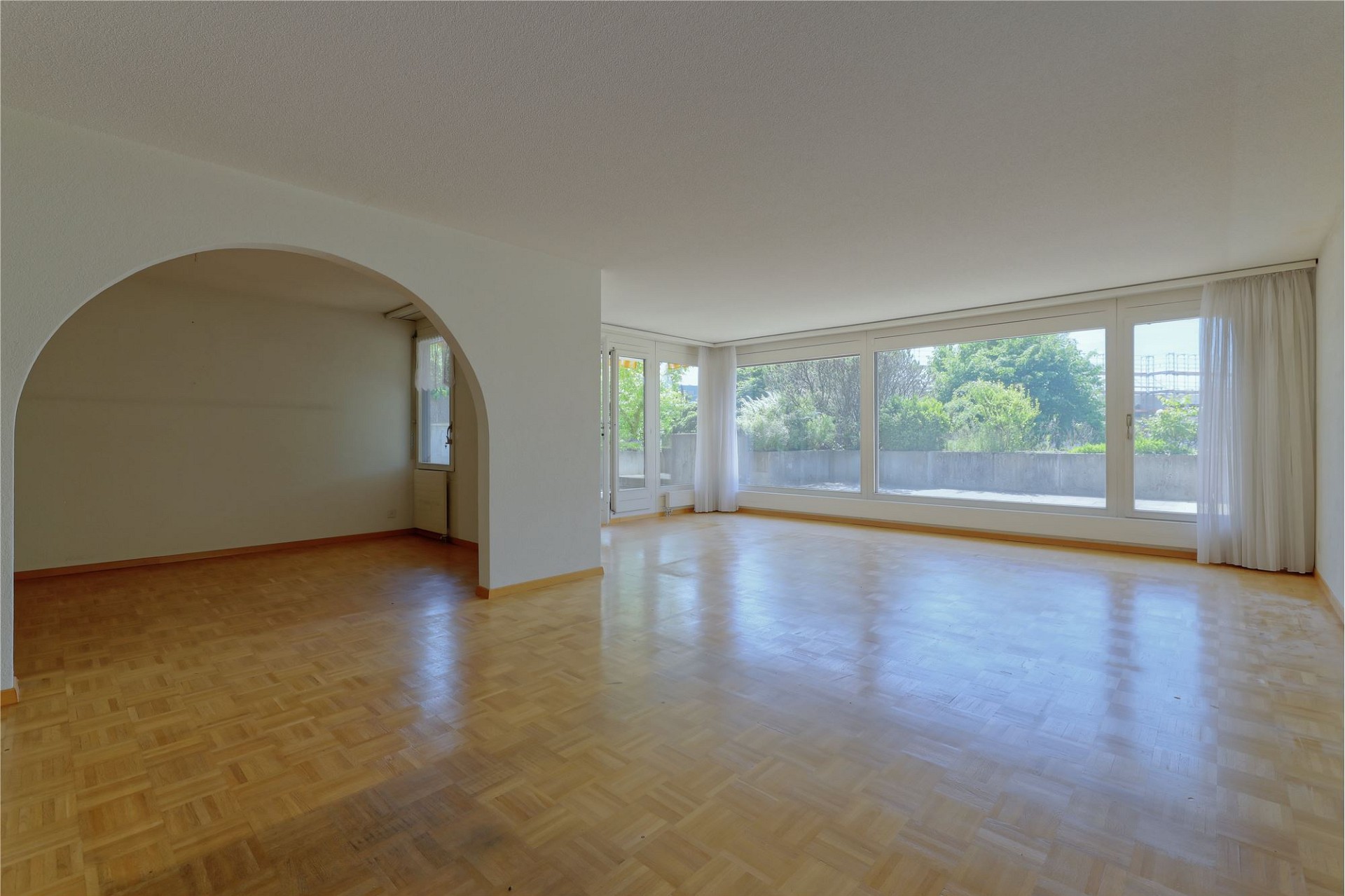 Heller Wohnraum mit Parkett und großen Fensterfronten